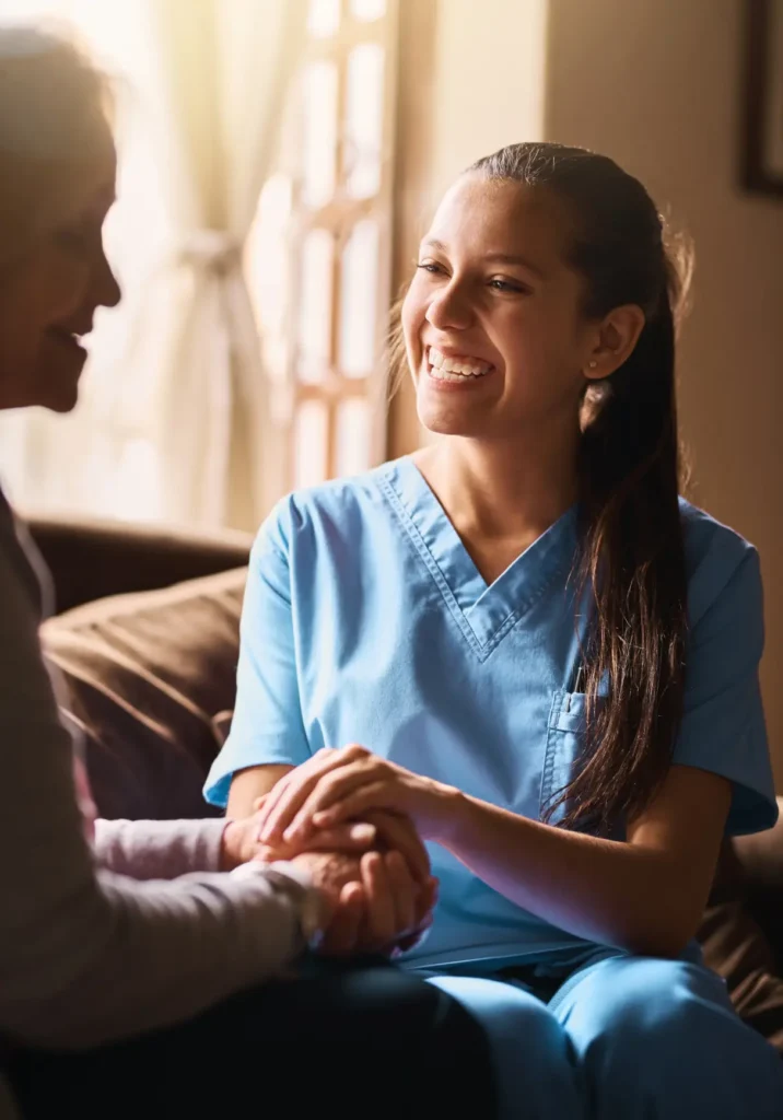 A compassionate caregiver gently holding the hand of a senior woman, representing the caring roles available in Washington County, Maryland.