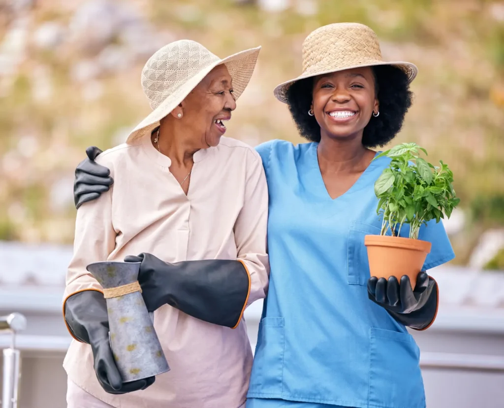 Caring in-home care nurse assisting a senior woman with gardening outdoors in Carroll County, Maryland.