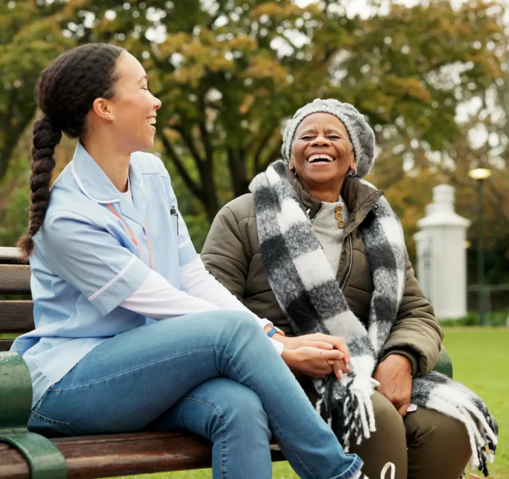 Compassionate in-home care nurse assisting a senior woman in a wheelchair in a park in Frederick County, Maryland.