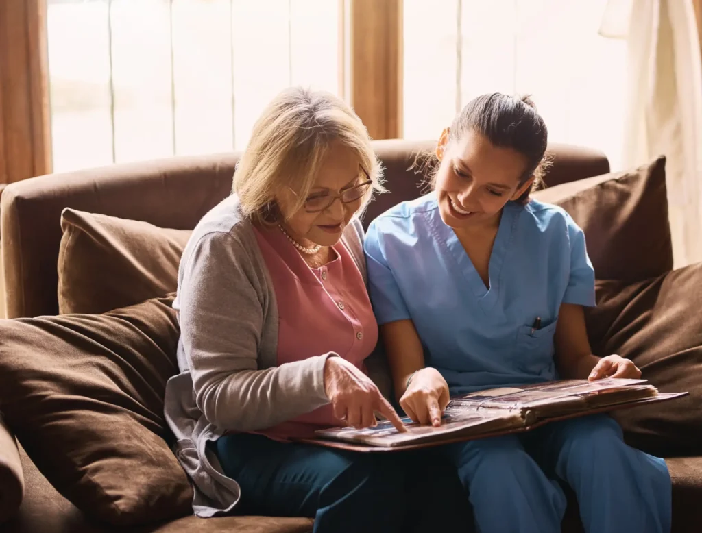 A compassionate in-home memory care professional in Maryland engages with a senior, triggering positive memories through reminiscence therapy.