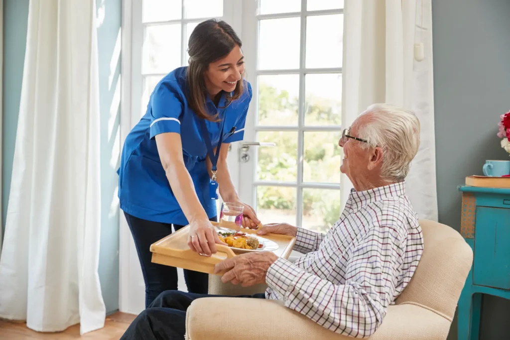 Caring in-home caregiver assisting elderly man with dinner as part of daily living support in Carroll County, Maryland