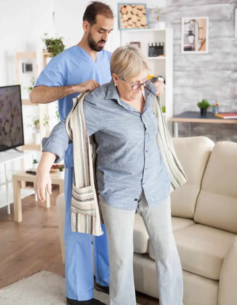 Compassionate caregiver assisting a senior woman with dressing in her Washington County, Maryland home, as part of personalized in-home care.